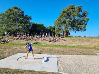 A person throwing a disc in a field

Description automatically generated