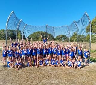 A group of kids in blue shirts posing for a photo

Description automatically generated