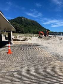 A construction site with a hill in the background

Description automatically generated