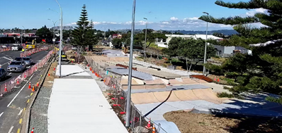 A skate park with a road and trees

Description automatically generated