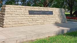 A stone wall with a sign on it

Description automatically generated