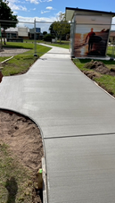 A concrete walkway with dirt and grass

Description automatically generated