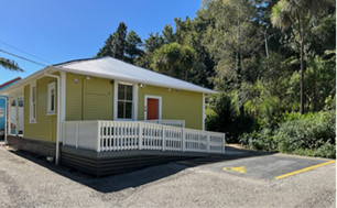 A yellow house with a white railing

Description automatically generated